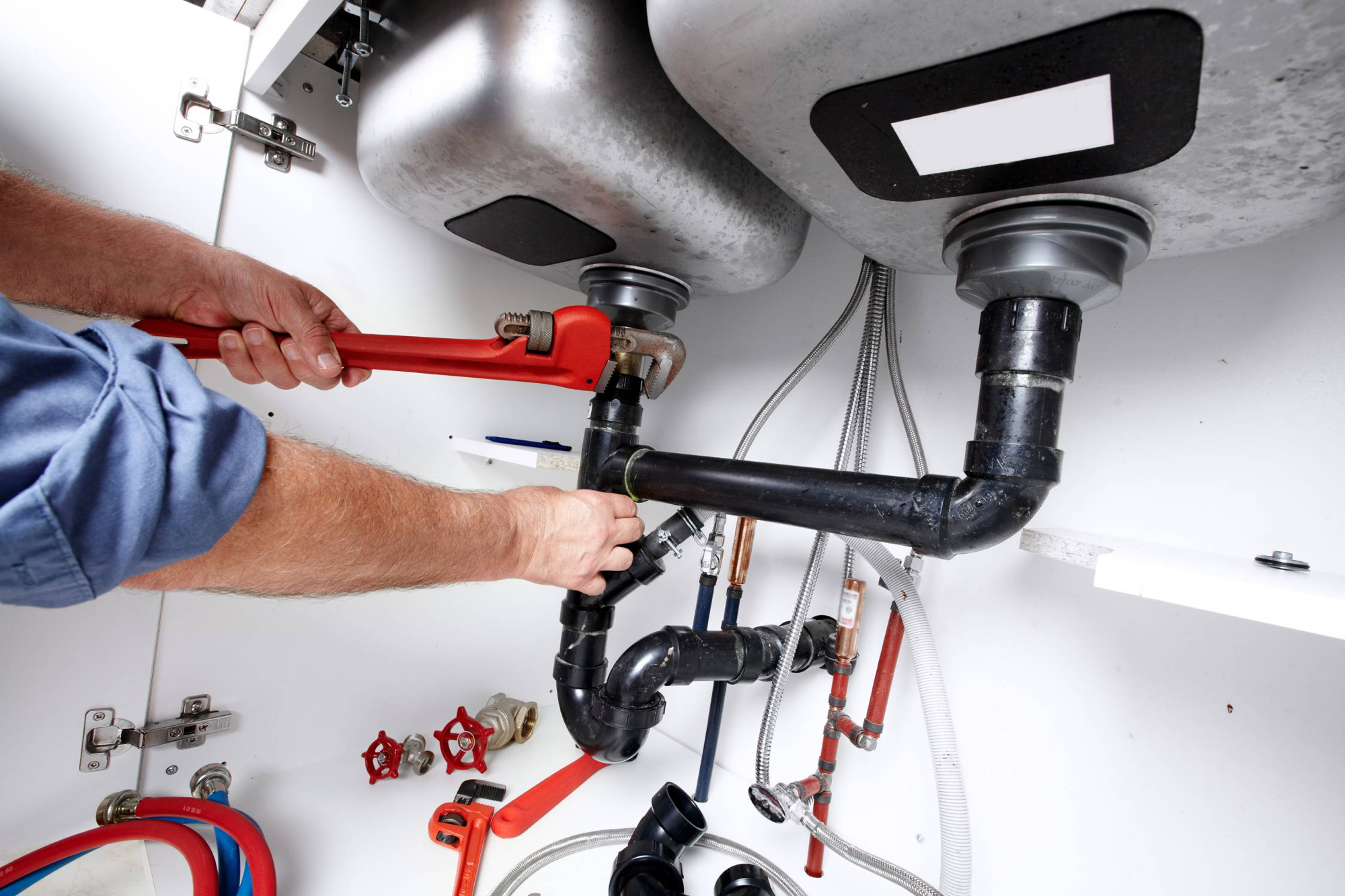 Plumber working under a kitchen sink